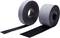 Two rolls of black adhesive tape, one lying down and partially unrolled, the other standing upright.