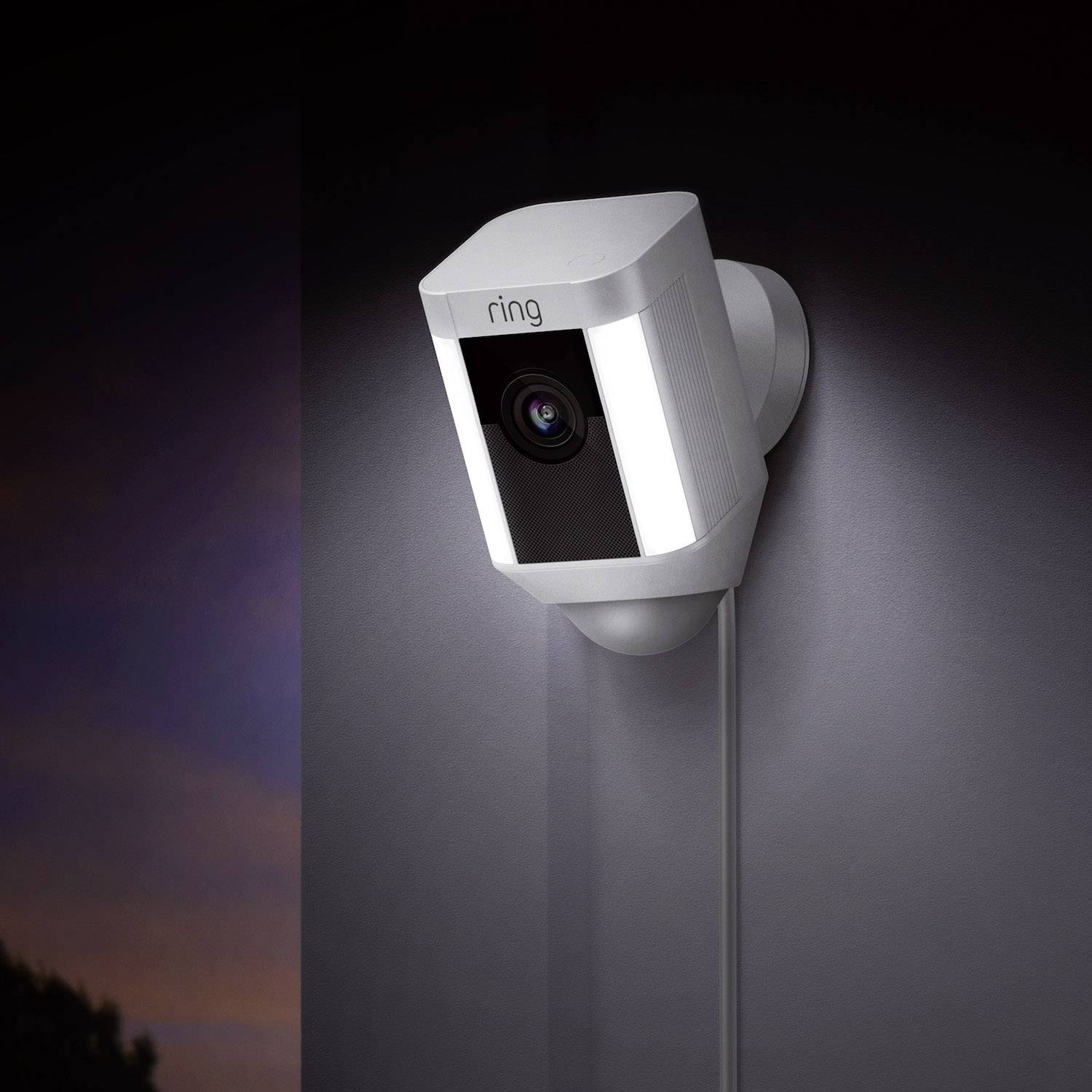 Wall-mounted security camera, suitable for home surveillance. It is white and connected to a power plug.