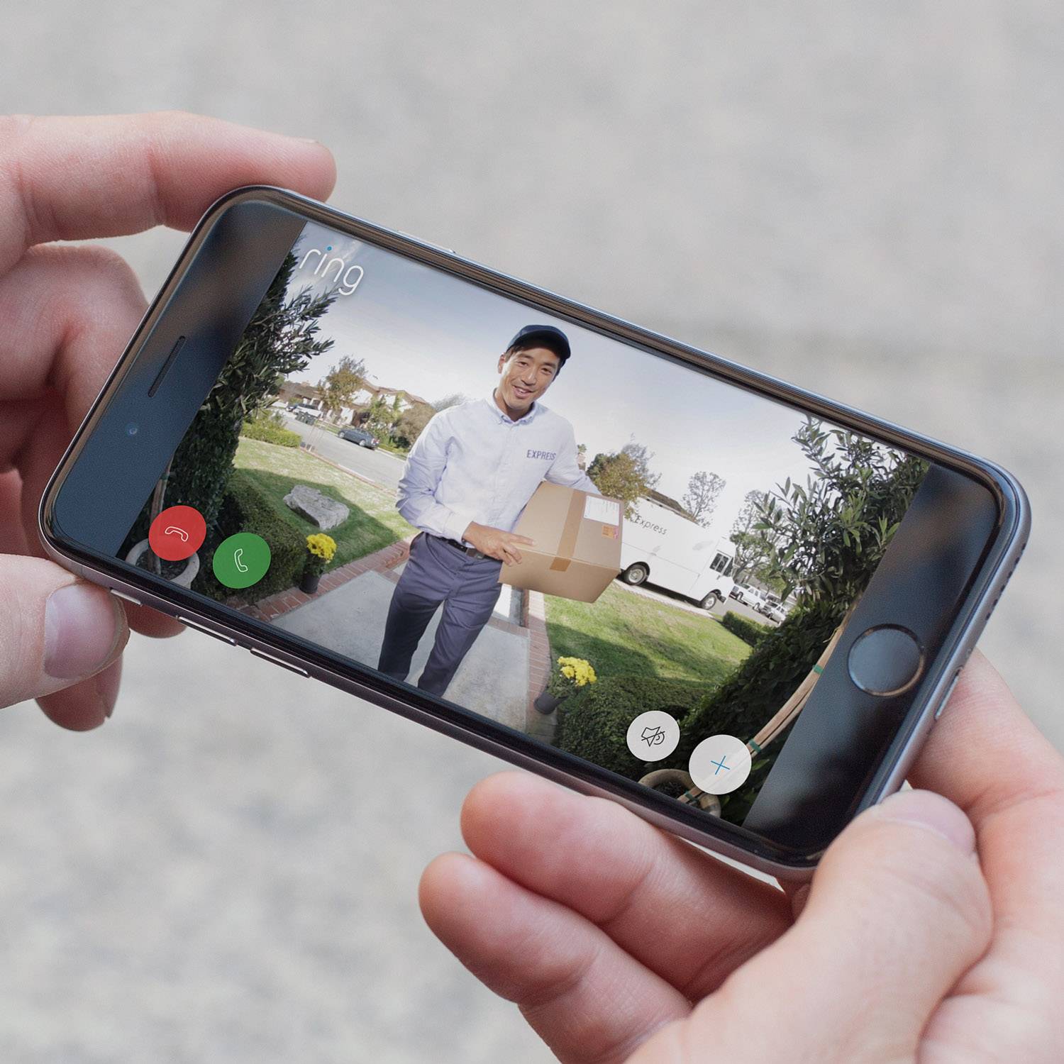 A mobile phone displays a video call with a delivery person holding a package in front of a front door. The app indicates a doorbell notification.