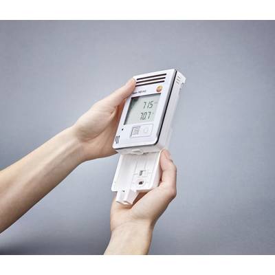 Hands are holding a digital device with a display showing temperatures. The device is being opened to change the battery.