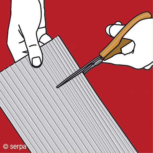 'Hand cutting corrugated cardboard with a craft knife against a red background.'