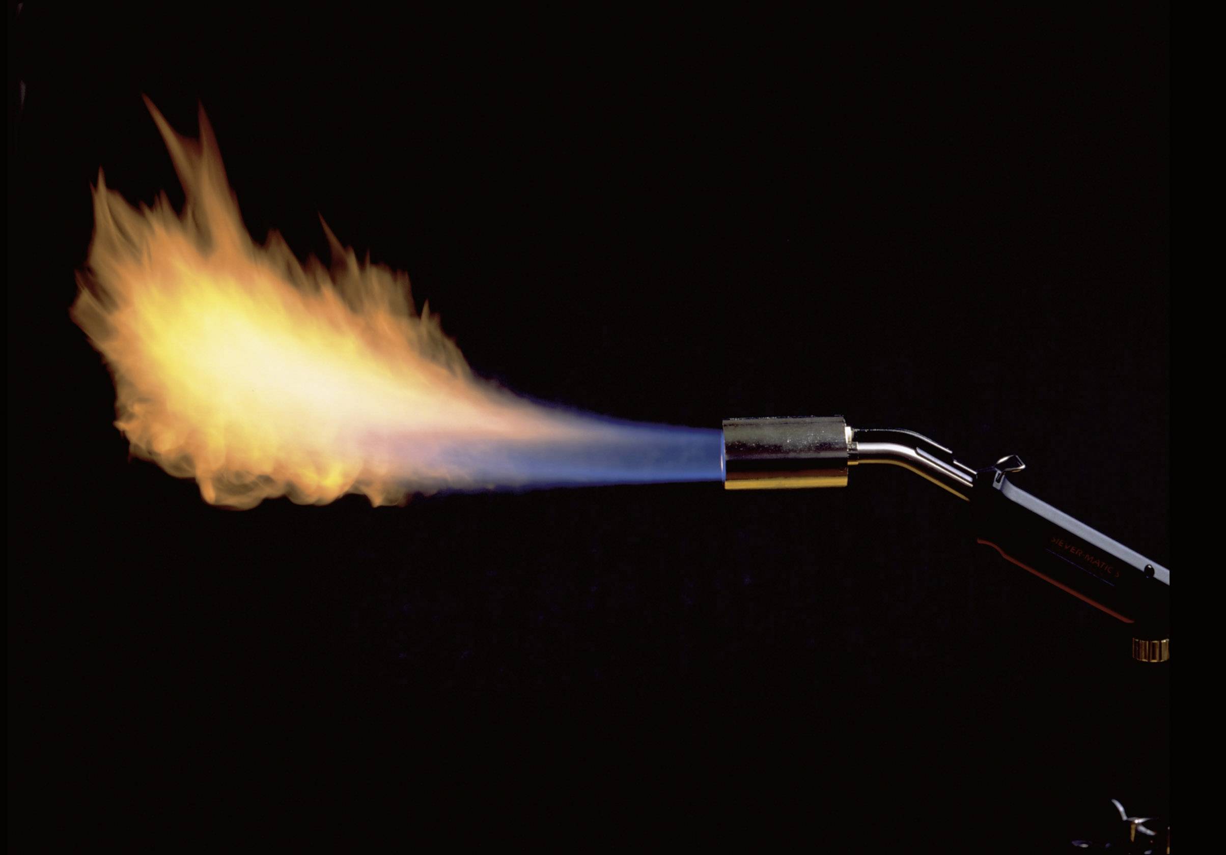 A burner emits a hot flame that transitions from blue at the end of the burner to orange at its tip.