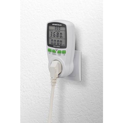 A power meter is plugged into a socket, displays consumption values on a digital display, and has a white border.