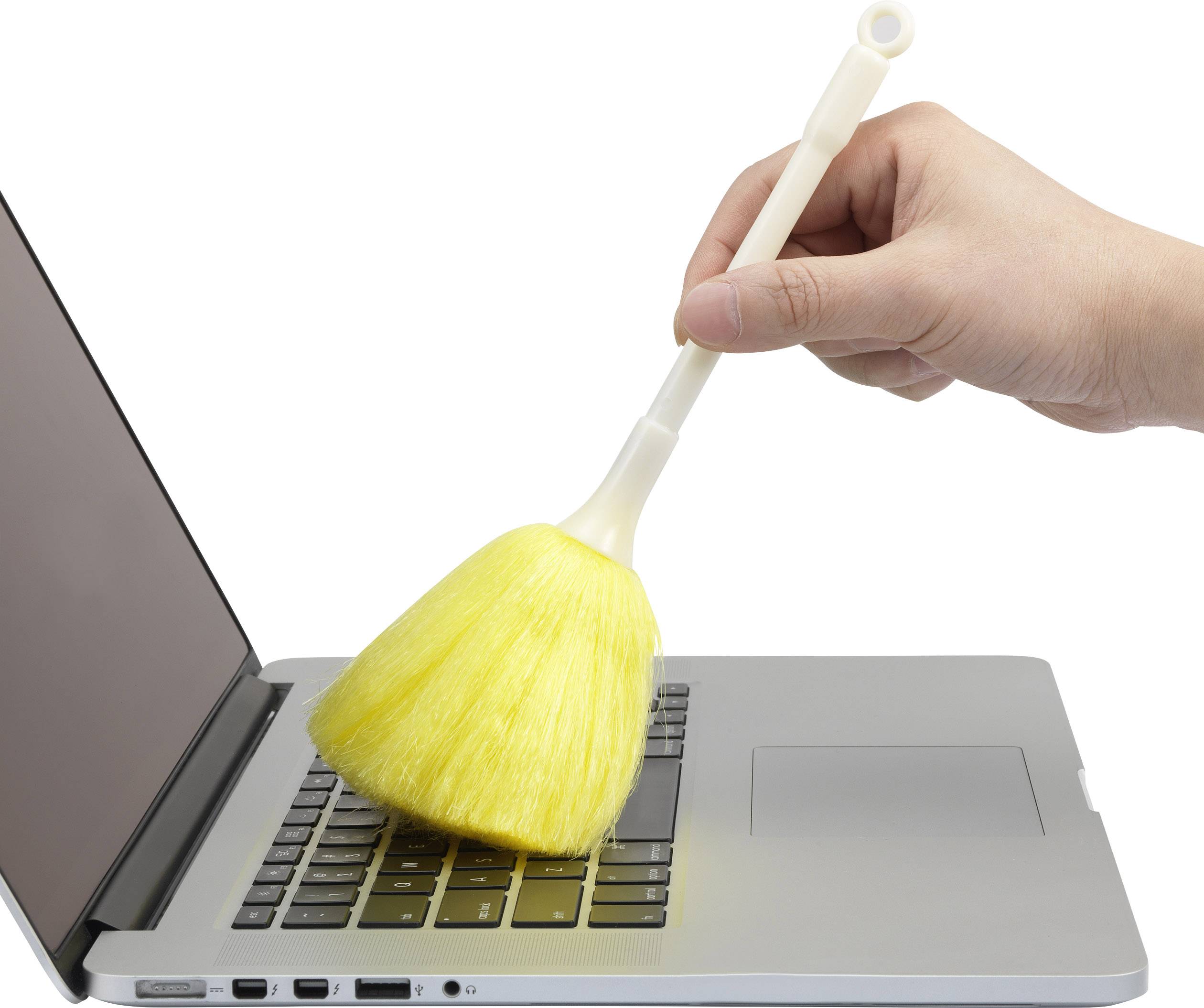 A hand is cleaning a laptop keyboard with a yellow brush head.