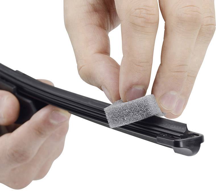 'Hands are holding a windscreen wiper and cleaning it with a small sponge.'