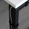 A white table with black metal legs. A cable is neatly secured along one table leg with a hook and loop fastener.