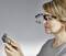 A person is wearing a magnifying glasses with light to inspect an electronic circuit board.