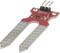 Soil moisture sensor with two metallic probes for measuring moisture in the earth, mounted on a red printed circuit board.