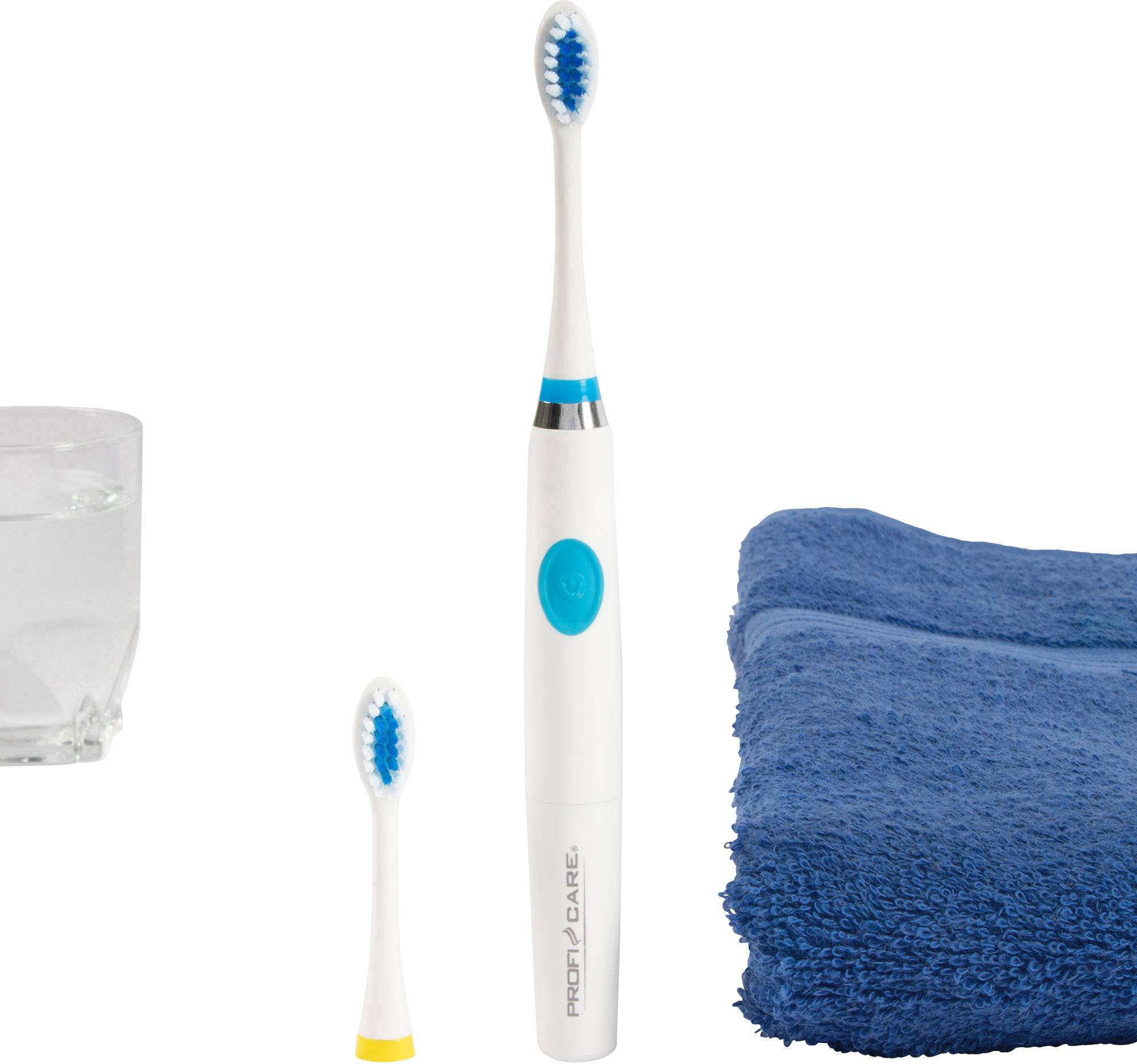 Electric toothbrush with replacement brush head, blue towel and toothbrush glass on white background.