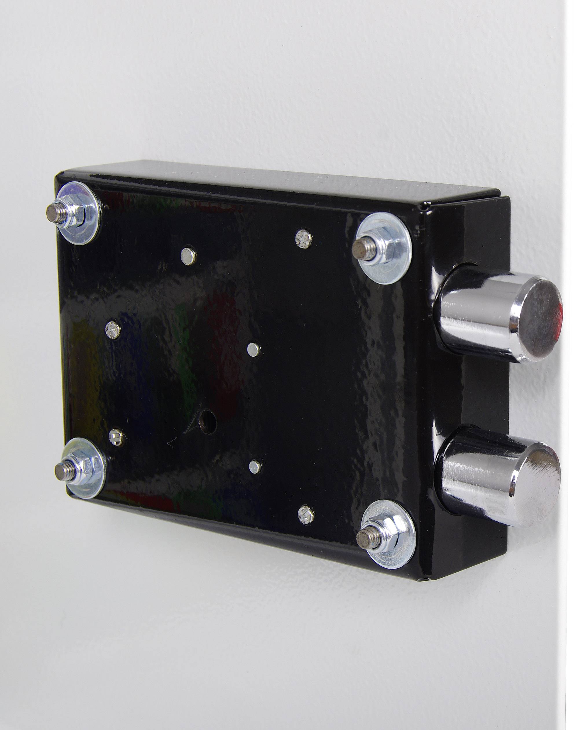 Black metal box lock with two rotary knobs, mounted on a white wall.