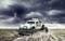 An off-road truck drives through muddy terrain beneath a dark, cloudy sky. Splashes of mud and water emphasise the drama.