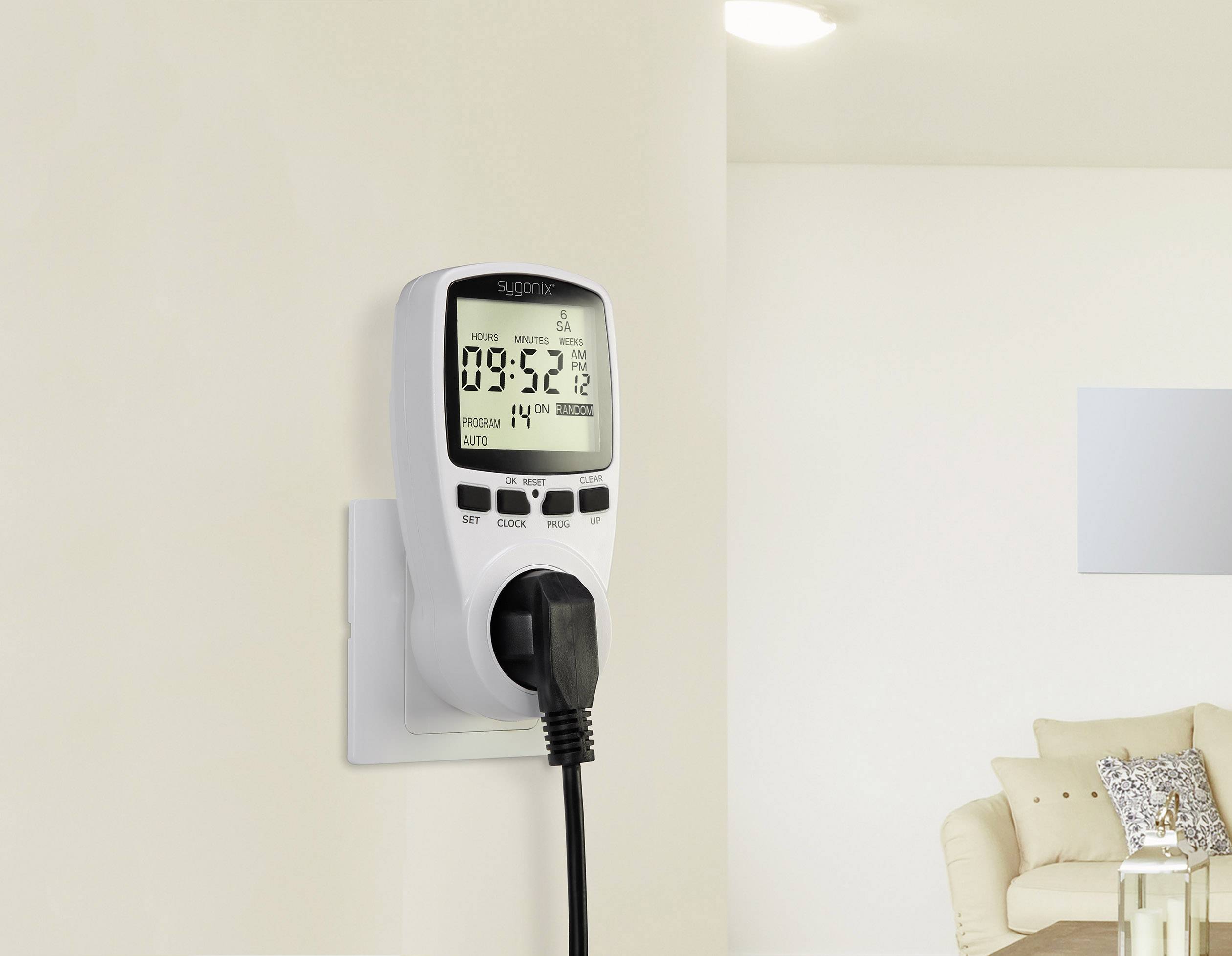 A digital timer is plugged into a socket, displays the time as 09:52, and controls a connected device.