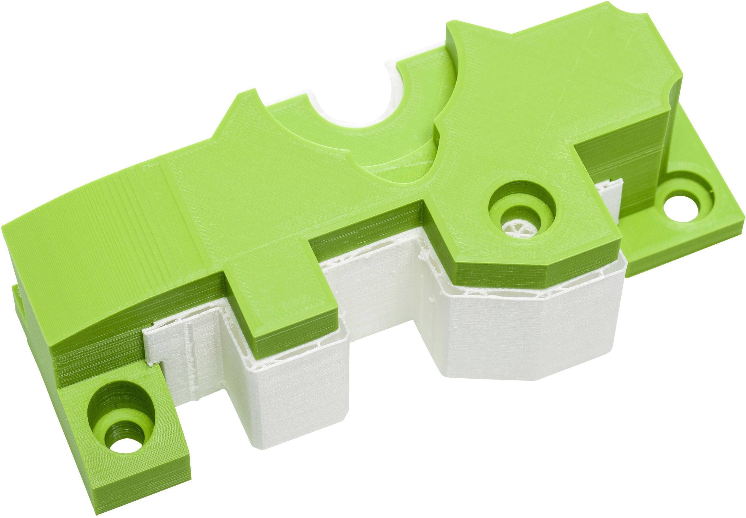 Green and white plastic component in a complex geometric form, potentially a part or casing for technical applications.