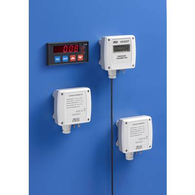 'Three pressure transmitters and a digital display device on a blue wall. The display shows a value of 0.08.'