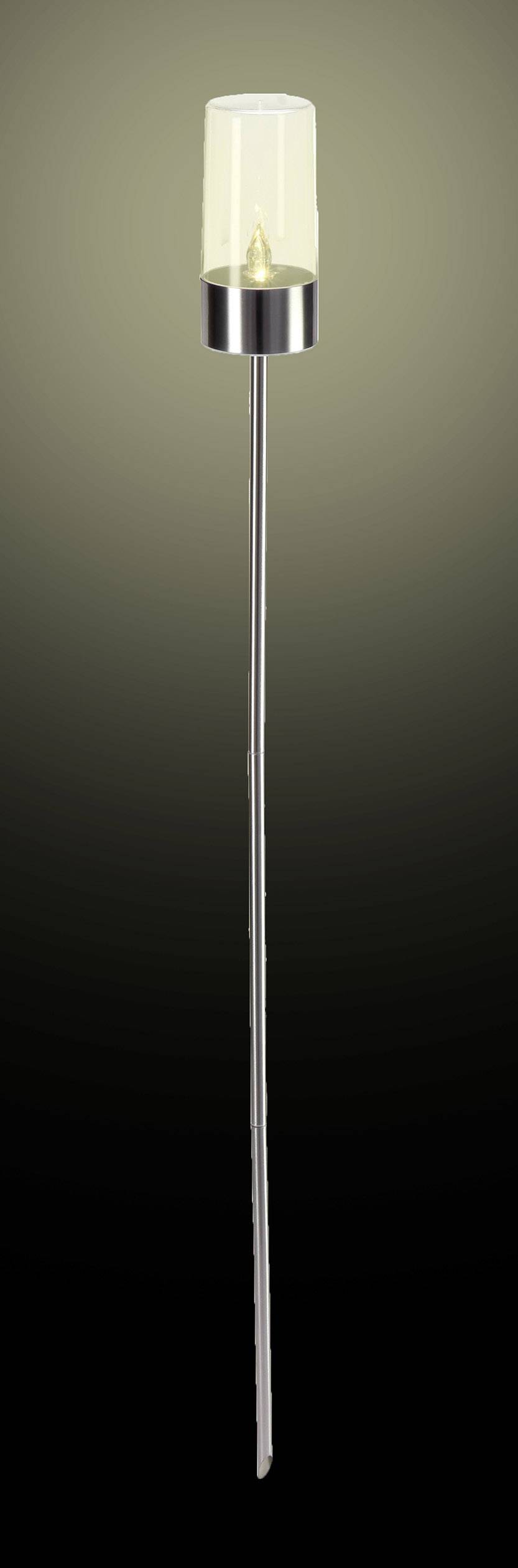 A slender floor lamp with a silver stem and glass shade, illuminating a dimmed room.
