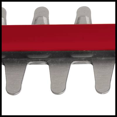 Close-up of a hedge trimmer with metal teeth and a red protective strip above it.