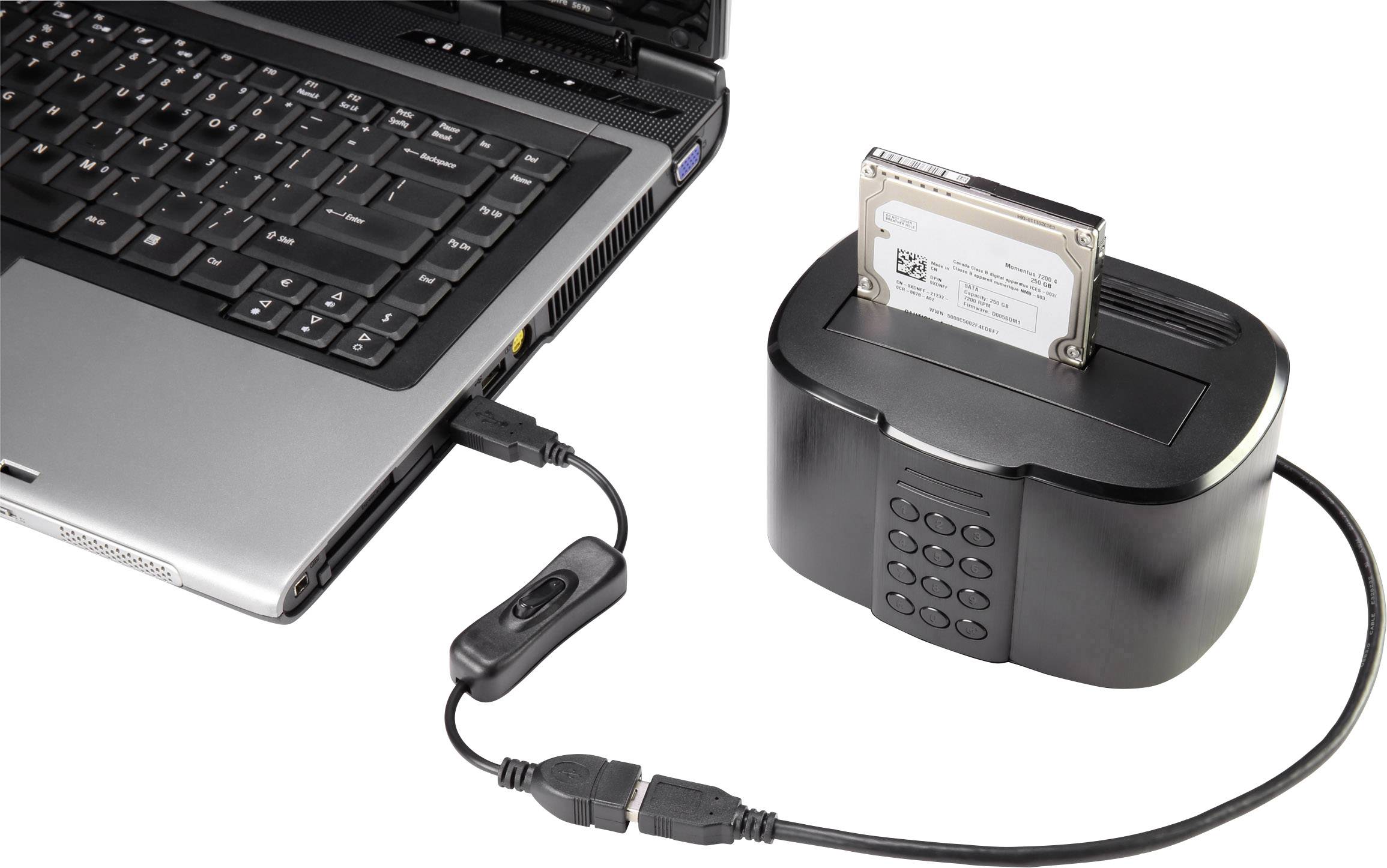 A laptop is connected to an external hard drive docking station via a cable. A hard drive is inserted into the docking station.