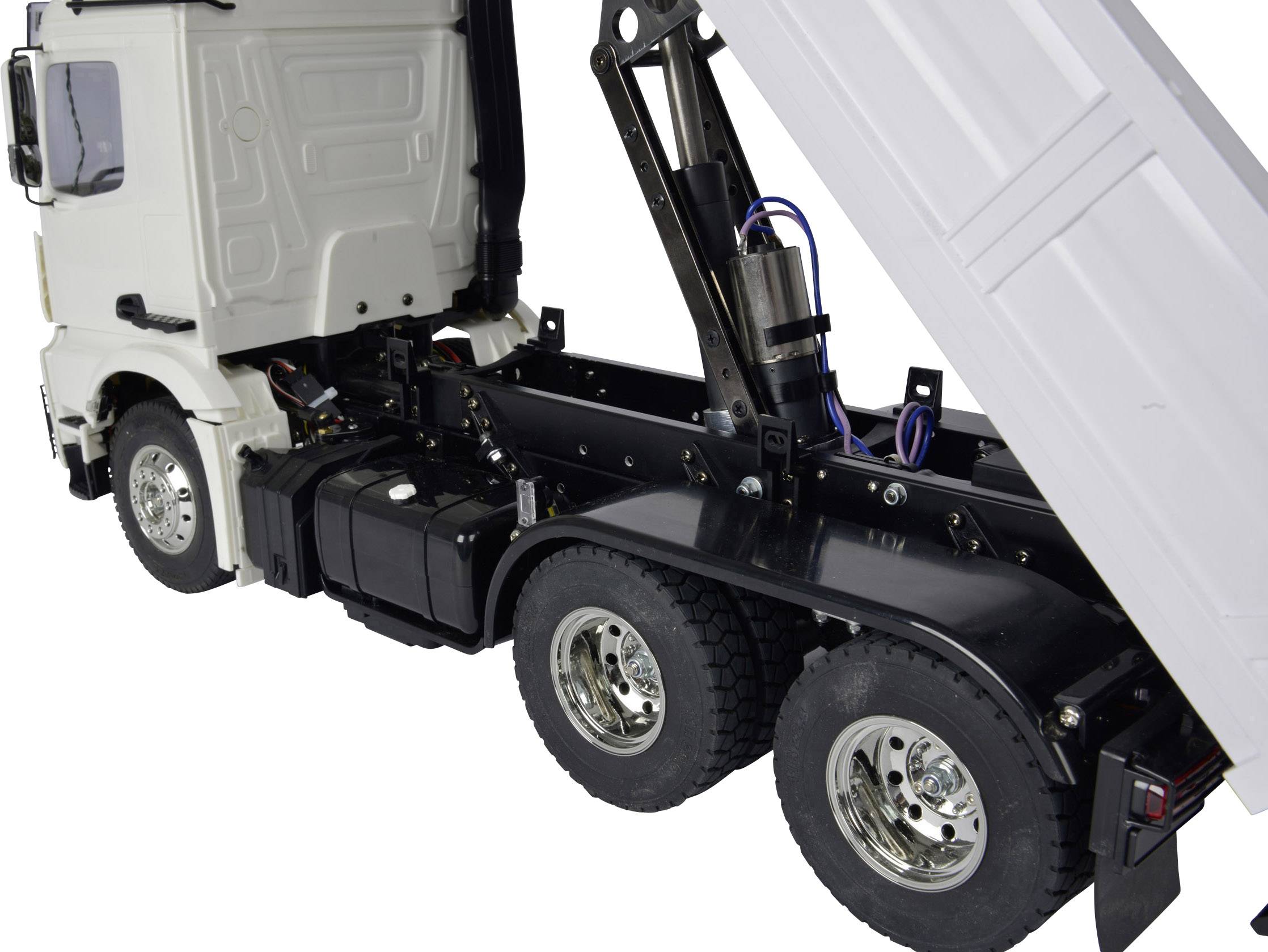 Lorry with trailer raising its loading bed. Demonstrates hydraulic mechanism and tyres.