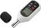 Sound level meter with display and control buttons, microphone cover beside it. Used for measuring noise levels.