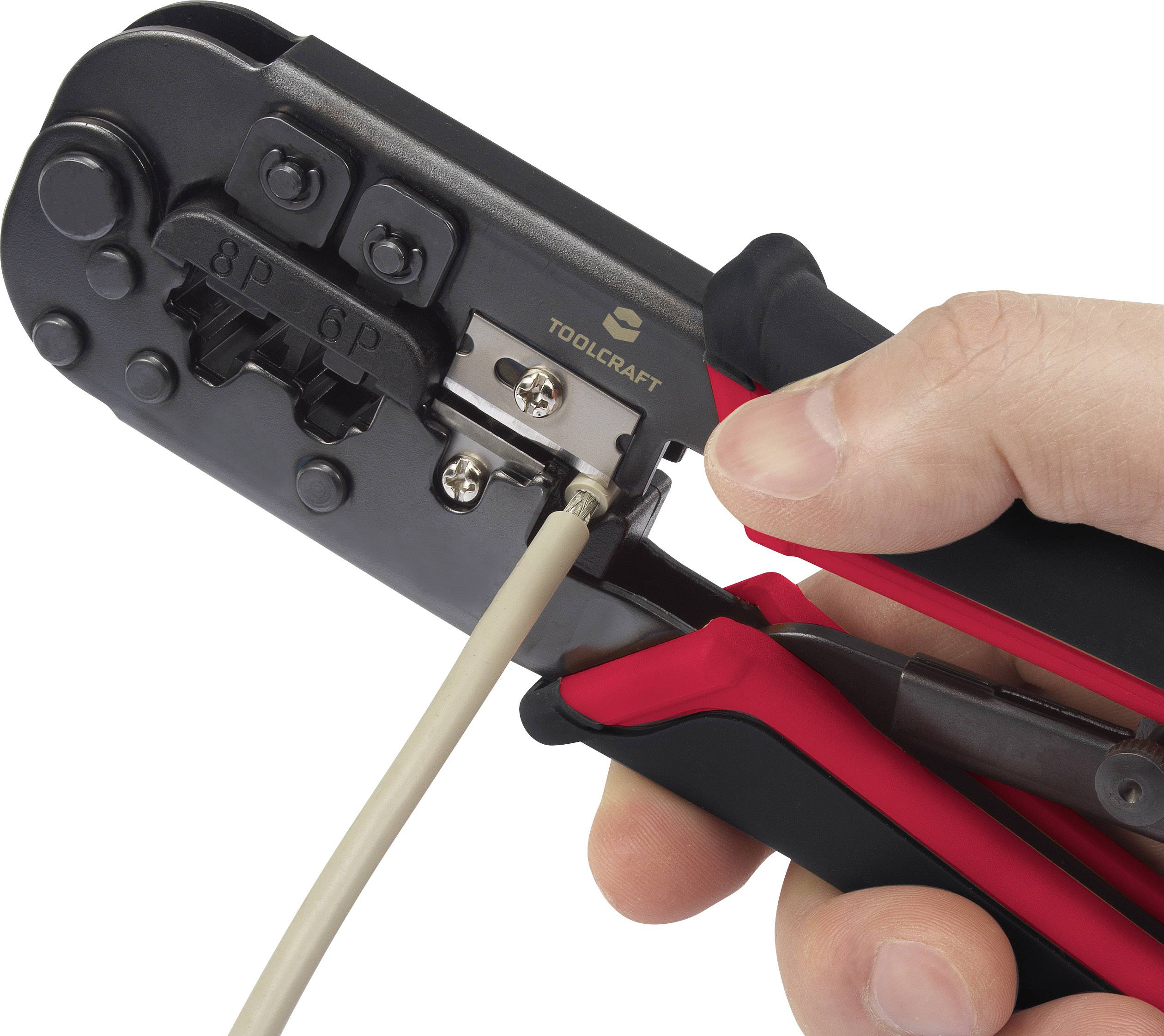 A hand is using a crimping tool to attach an RJ45 connector to a cable. The pliers are black with red handles.