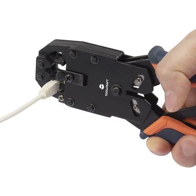 A hand holds a crimping tool that is working on a network cable.