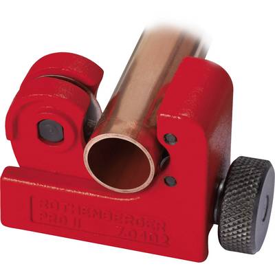 A red pipe cutter is cutting a copper pipe. The device has a screw-like mechanism for precise cutting.