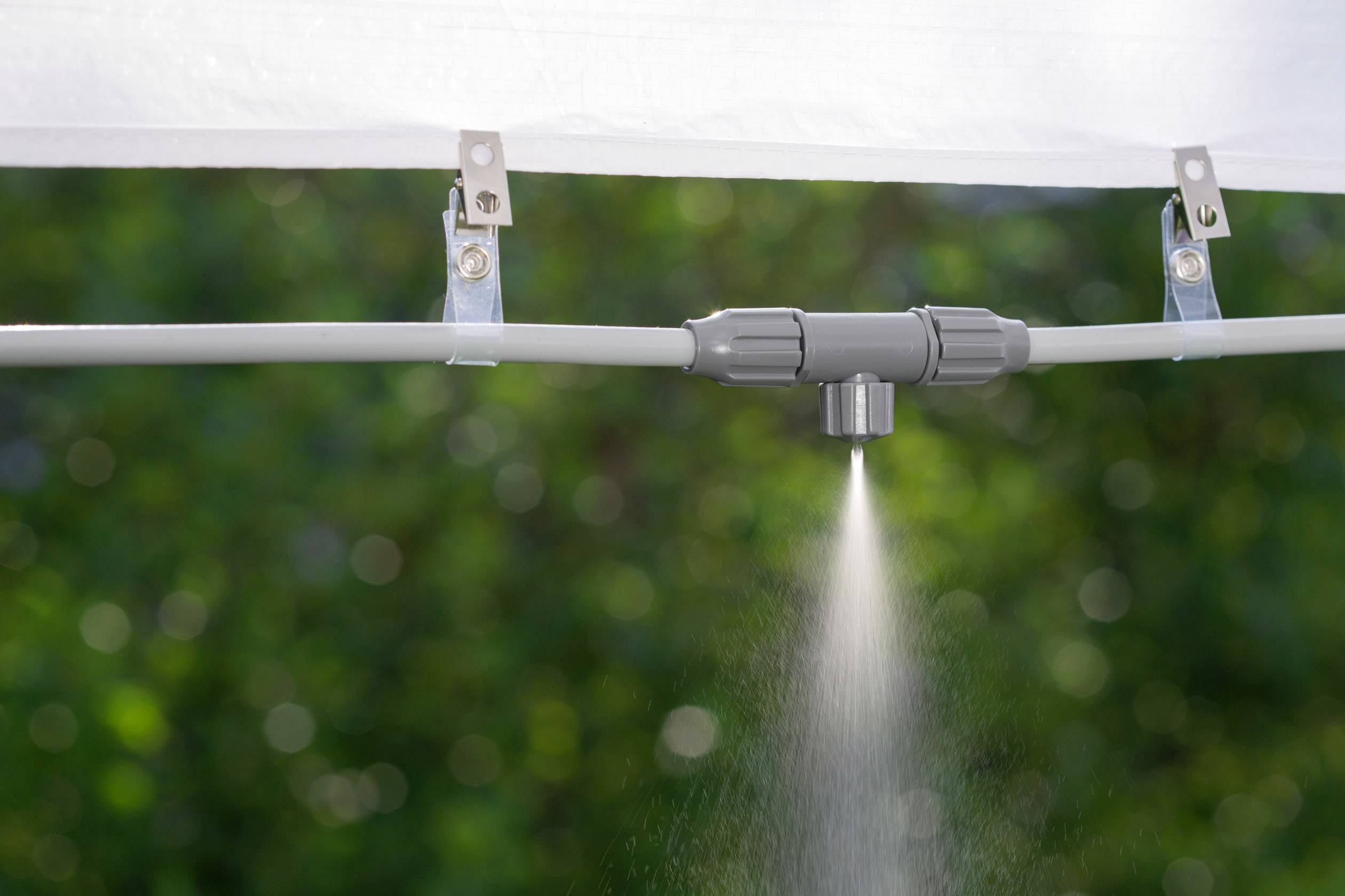 A watering system sprays a fine mist from a nozzle.