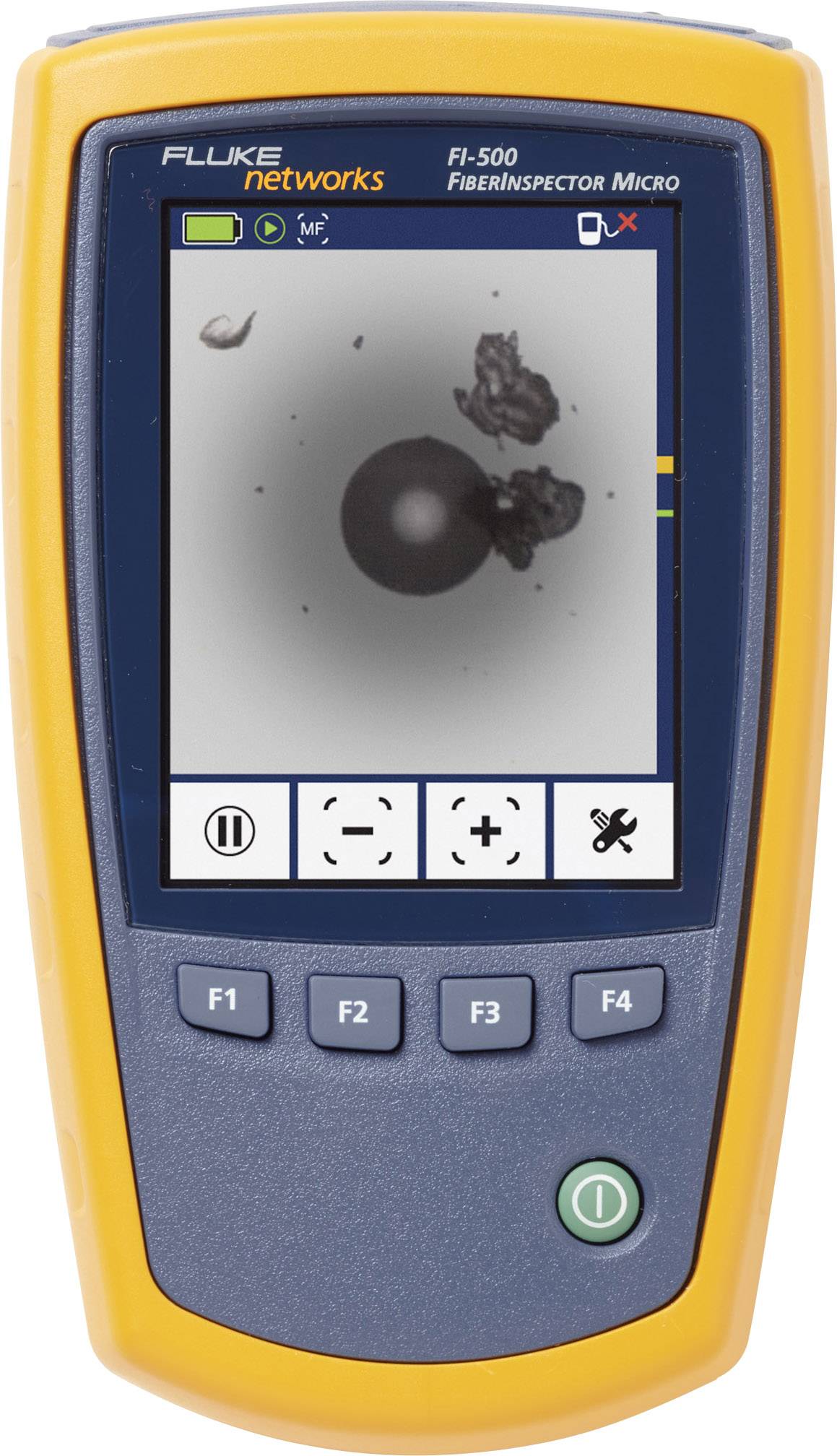 A portable inspection camera from Fluke Networks displays an enlarged image of an optical fibre end face with contamination on the screen.