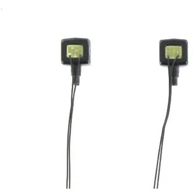 Two black square sensors with long cables hang vertically. They are positioned on a white background surface.