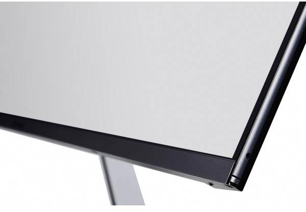 A modern, minimalist computer or television screen design with a sleek metal frame and a slender stand.