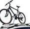 A black mountain bike is secured to a roof rack.