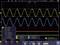 Oscilloscope display with two wave-like signals in Yellow and Blue. Yellow shows higher amplitude. Frequency 1000 kHz.