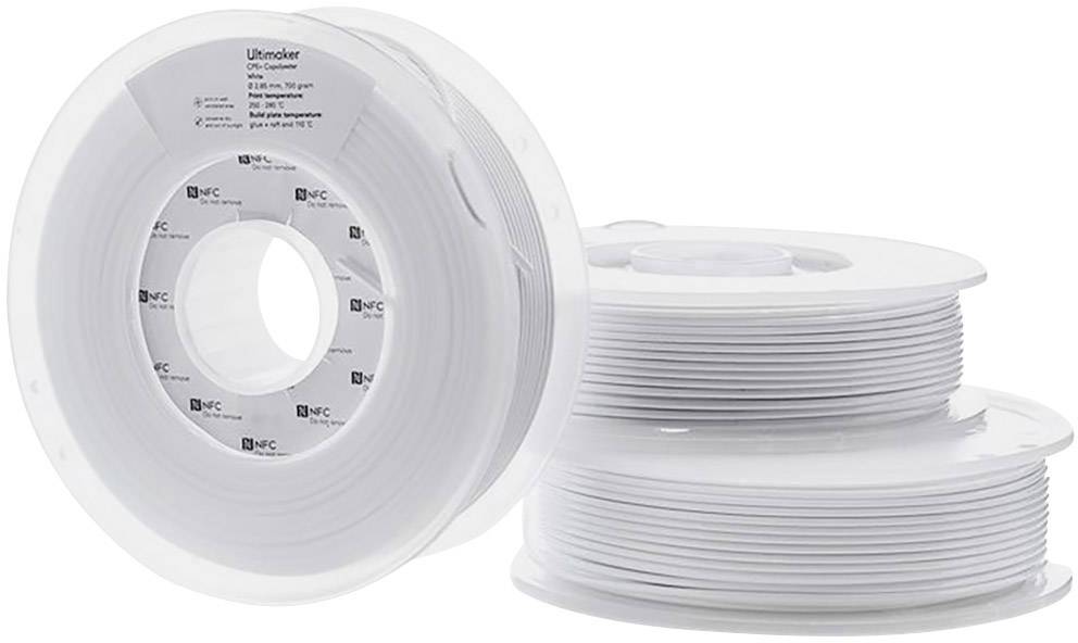 Several spools of white 3D printer filament on a table. One spool is standing upright, while the others are lying flat.