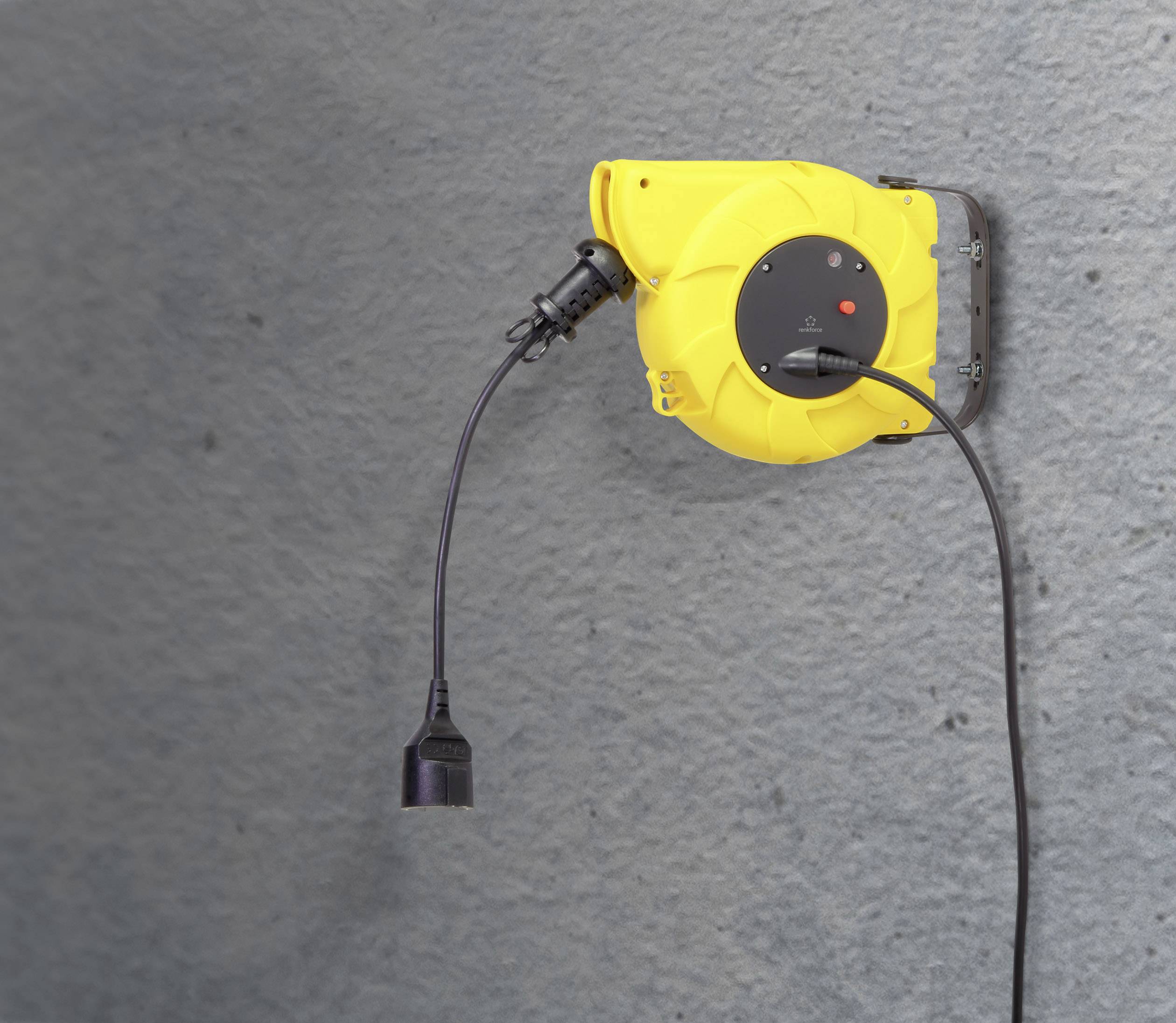 A yellow automatic cable reel mounted on a grey wall, with a black cable pulled out and a plug attached.