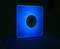 A luminous square with a central black circle on a dark background. The blue lends the scene a futuristic atmosphere.