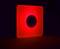 A glowing, square red sign with a darker circle in the centre, presumably a decorative night light.