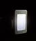 Nightlight plugged into a wall socket, glowing softly in the dark, rectangular in shape, with a white frame.