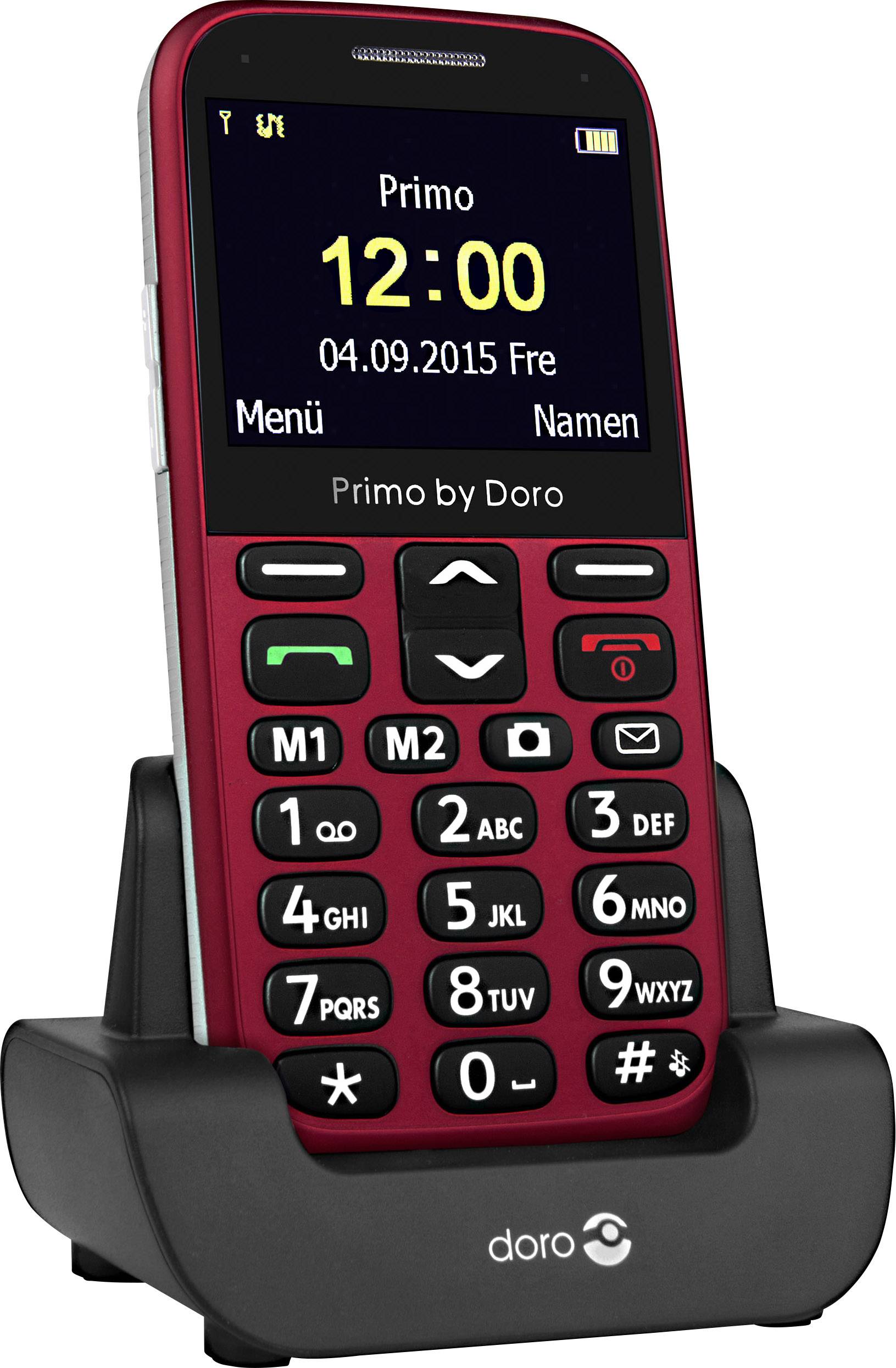 A red mobile phone with large buttons, standing on a black charger. The screen displays 'Primo by Doro', time and date.
