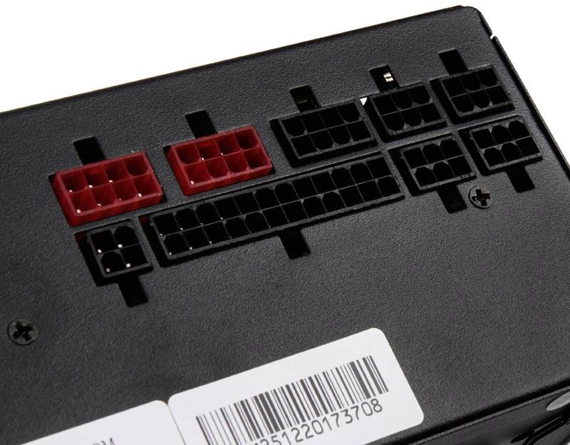 Black computer power supply with multiple slots for cable connections, including some red ports.