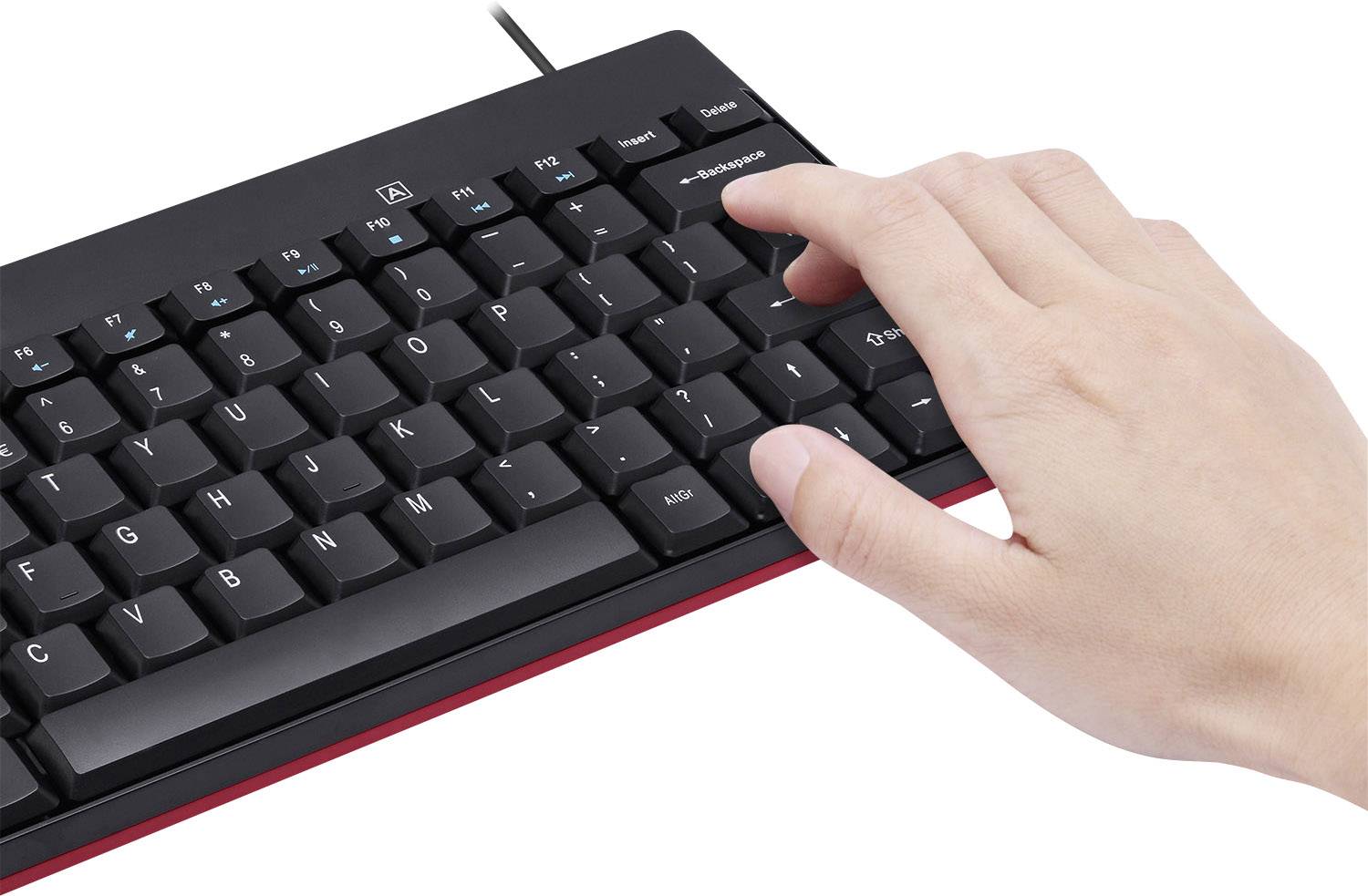 A hand is typing on a computer keyboard with black keys. The hand is positioned on the right and is pressing one of the keys.