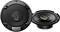 Round Kenwood speakers with a black grille at the front, a visible yellow ring, and a second speaker without a cover beside it.