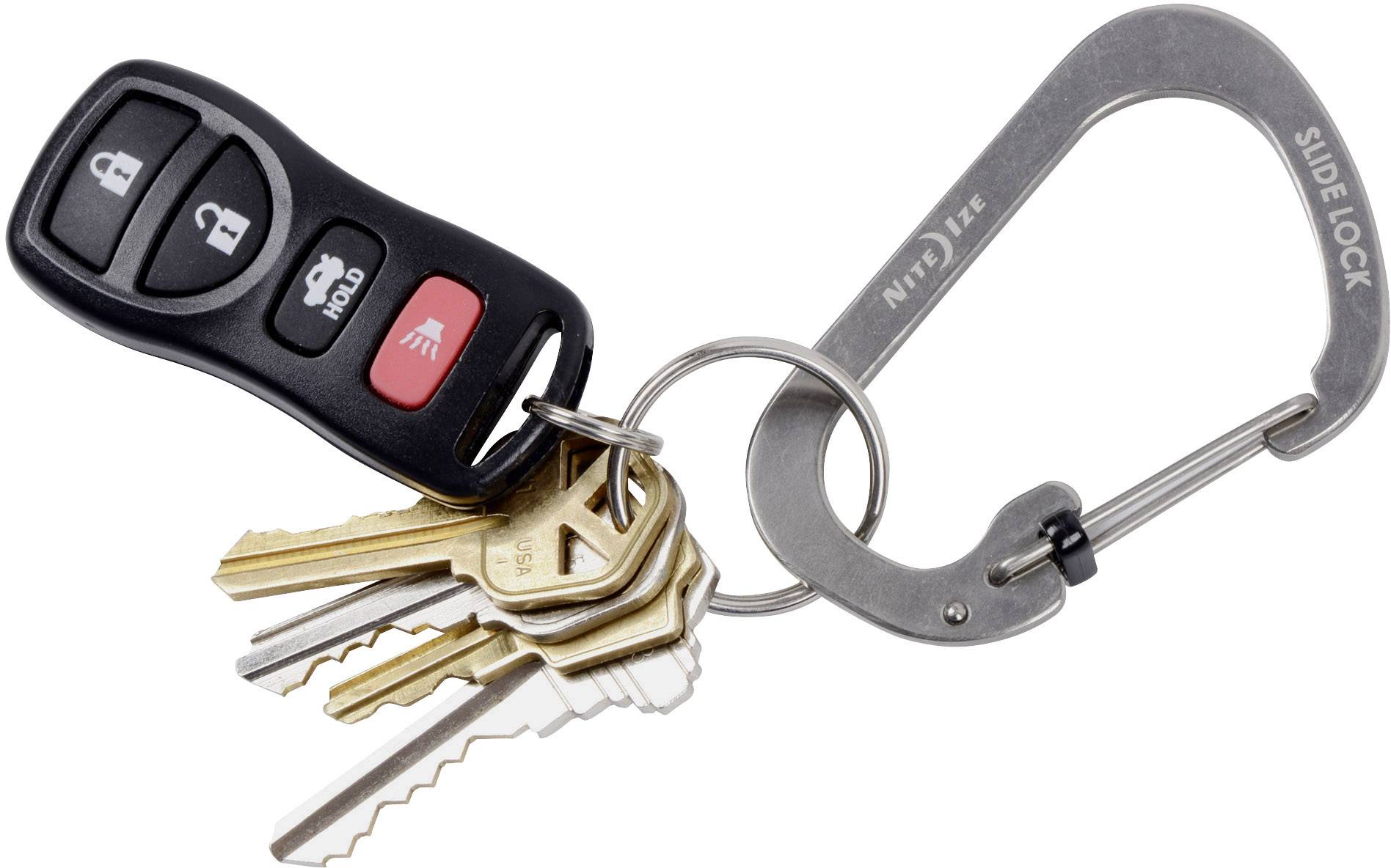 A bunch of keys on a keyring with a car key fob lies on a table.