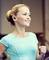A smiling woman in sportswear with wireless earphones is running indoors.