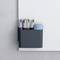 Whiteboard with a holder for four coloured pens and an eraser, mounted on a grey wall.
