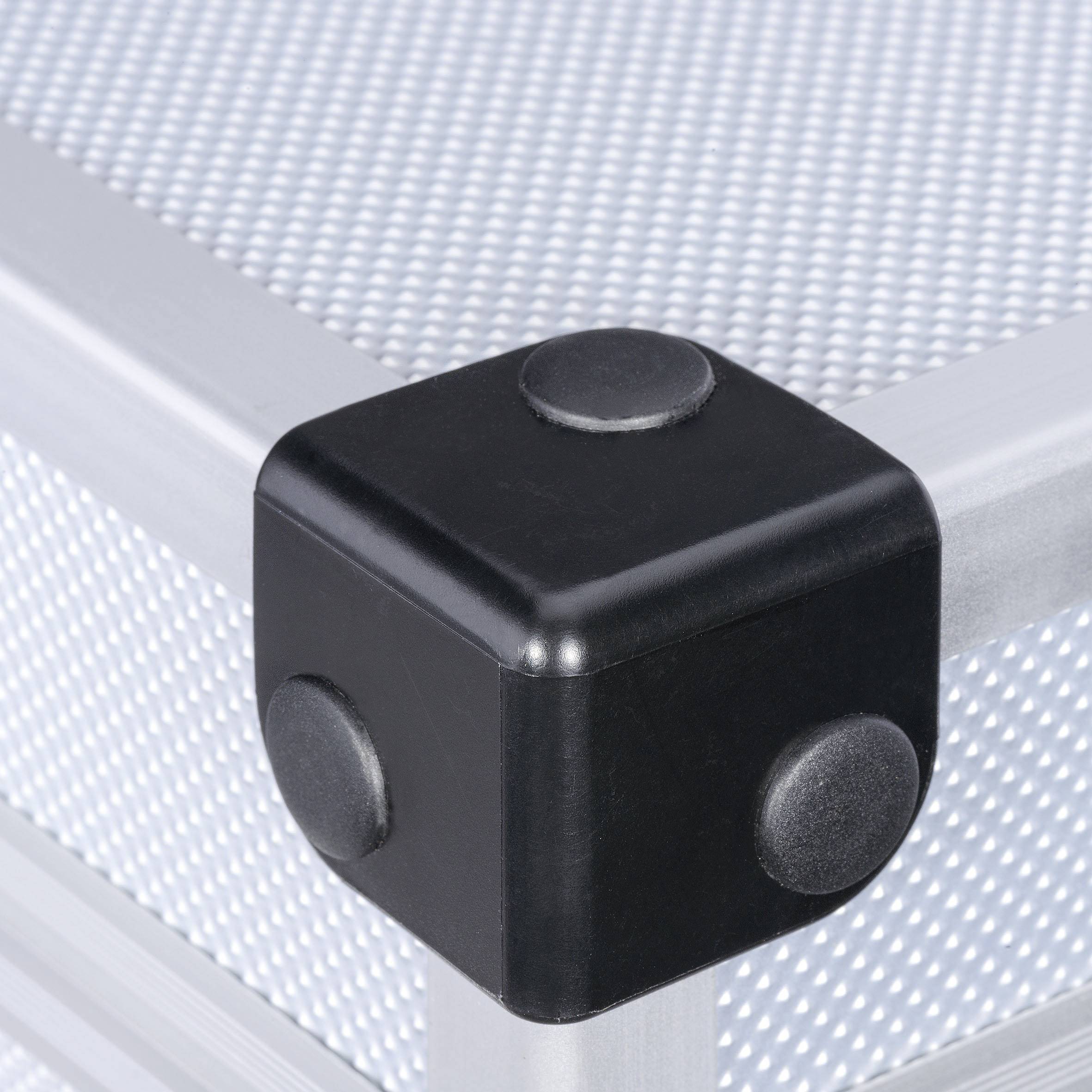 A black cubic element at the corner of a silver metal frame with a textured grey surface.