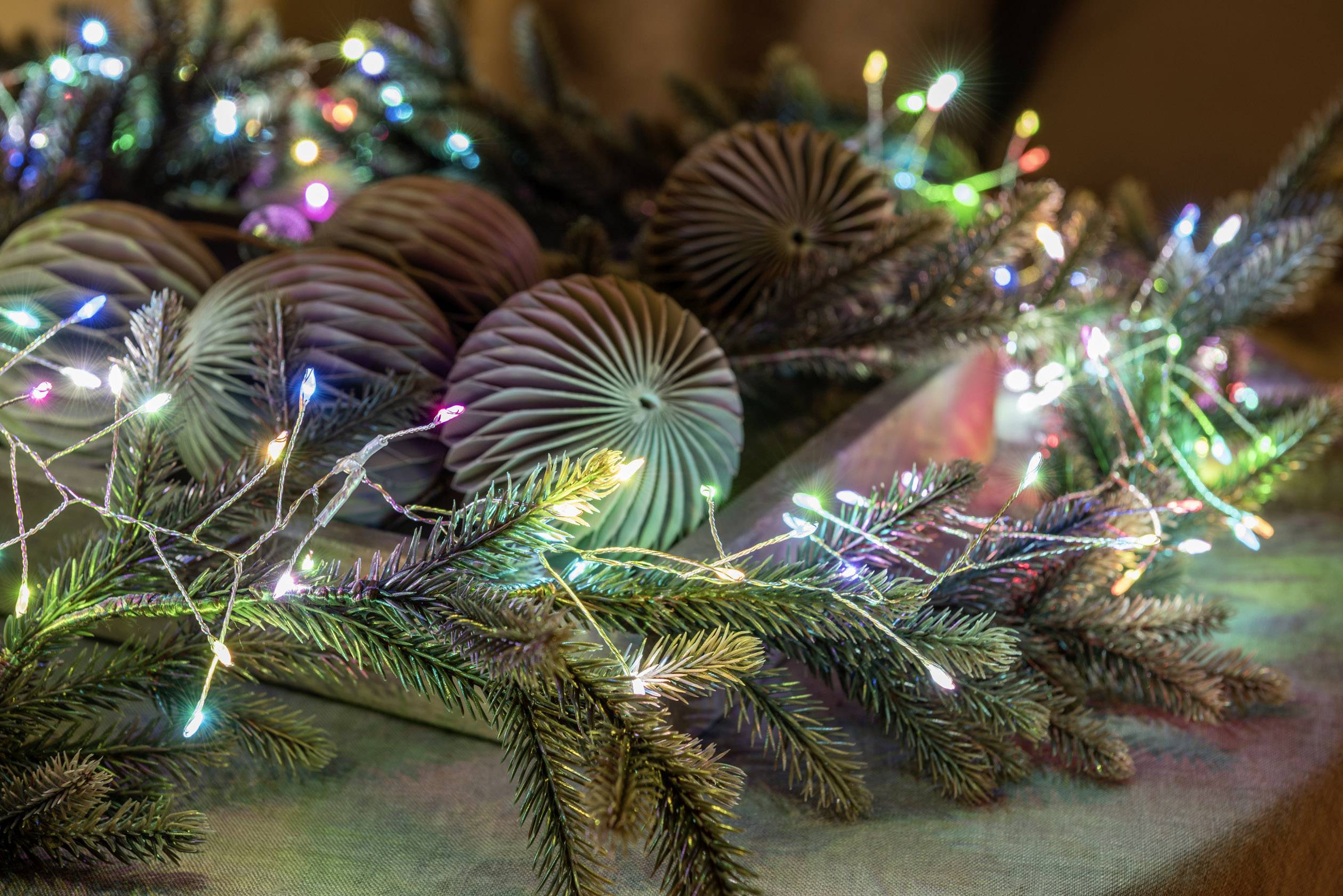 Christmas decorations with colourful lights, pine branches, and decorative baubles, create a festive atmosphere.