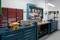 Workshop with workbench, bench vices, tool wall with various hand tools, drawer cabinets and machinery.