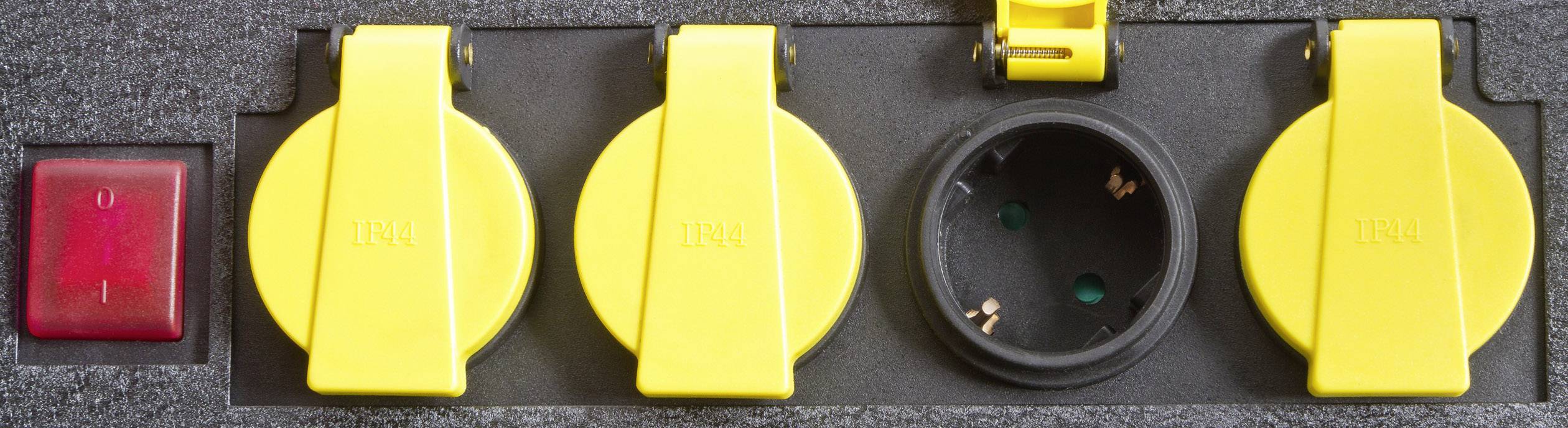 A power strip with yellow covers and an open socket, with a red on/off switch beside it.