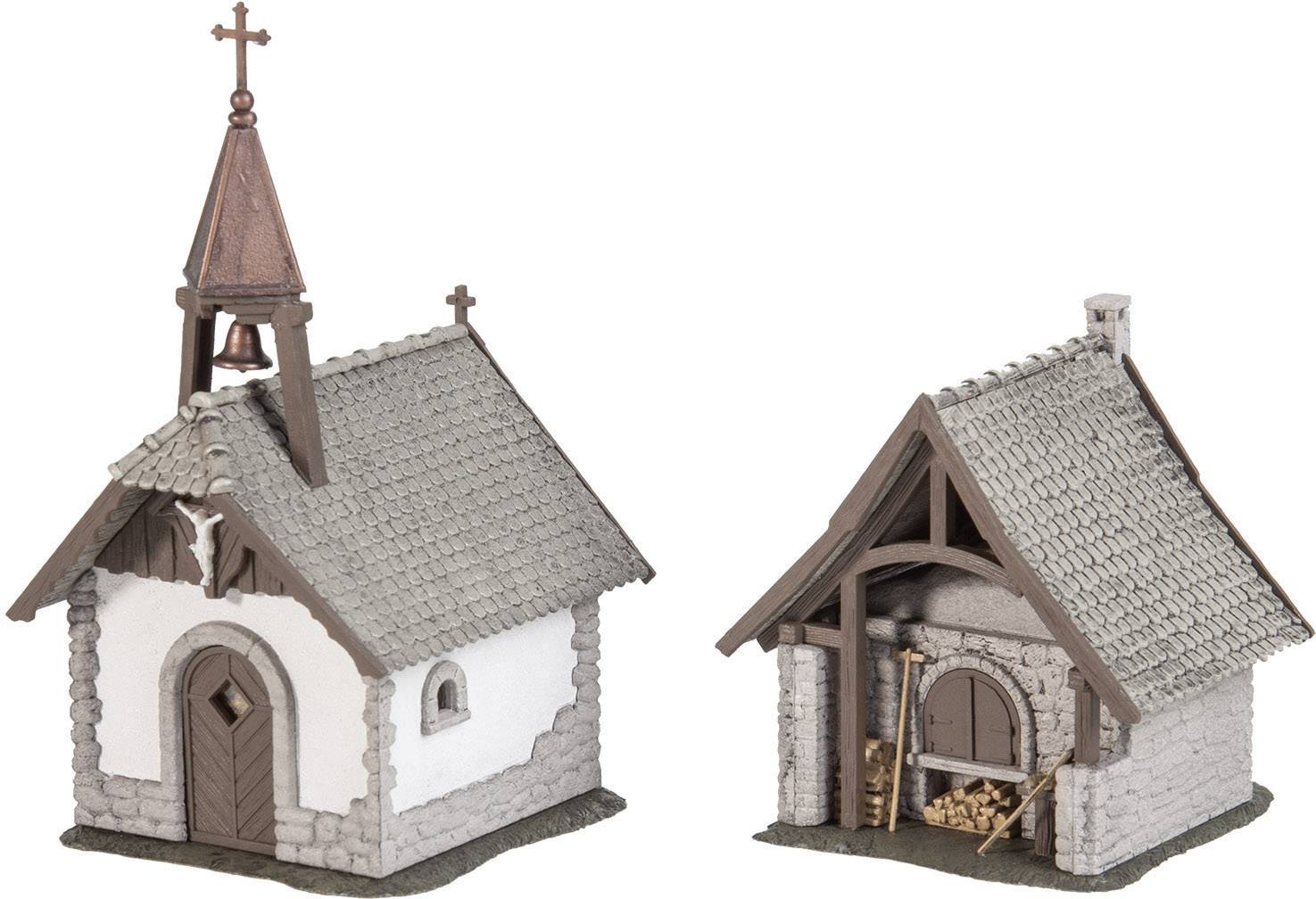 Two miniature buildings: A small chapel on the left with a spire, next to a barn with wooden bundles. Both in a rustic style.