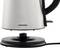 A silver Grundig kettle hovers above its round, black base station.